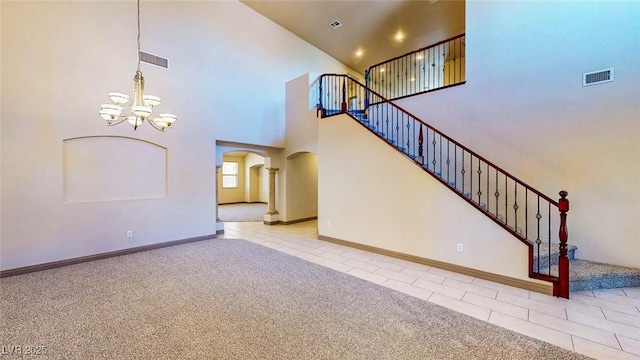 524 Blanche Ct, Henderson, NV 89052 - unfurnished living room featuring visible vents, carpet floors, arched walkways, a notable chandelier, and tile patterned flooring