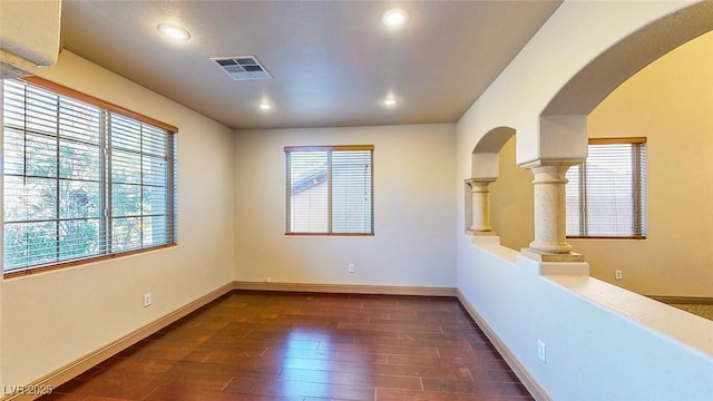 524 Blanche Ct, Henderson, NV 89052 - spare room with dark wood-style floors, visible vents, arched walkways, and plenty of natural light
