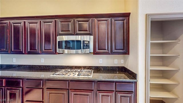 524 Blanche Ct, Henderson, NV 89052 - kitchen with dark stone countertops, reddish brown cabinets, and stainless steel appliances