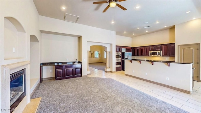 524 Blanche Ct, Henderson, NV 89052 - unfurnished living room with light tile patterned floors, arched walkways, ceiling fan, and a high end fireplace