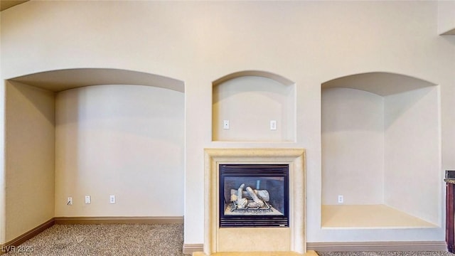 524 Blanche Ct, Henderson, NV 89052 - interior details with a glass covered fireplace, carpet flooring, arched walkways, and baseboards