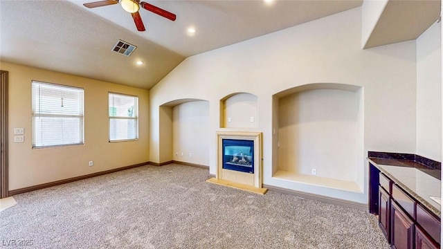 524 Blanche Ct, Henderson, NV 89052 - unfurnished living room with vaulted ceiling, ceiling fan, carpet flooring, a glass covered fireplace, and visible vents