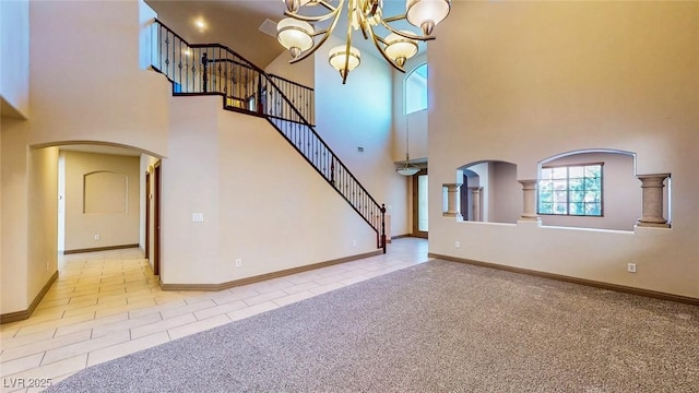 524 Blanche Ct, Henderson, NV 89052 - unfurnished living room with an inviting chandelier, tile patterned floors, arched walkways, and a high ceiling