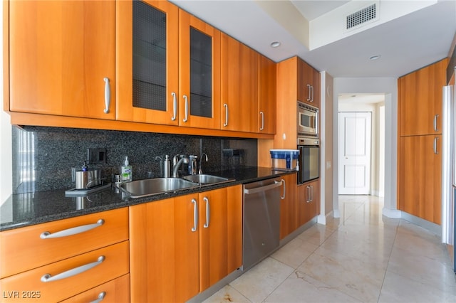 2877 Paradise Rd Unit 1806, Las Vegas, NV 89109 - kitchen with appliances with stainless steel finishes, brown cabinets, dark stone countertops, tasteful backsplash, and a sink