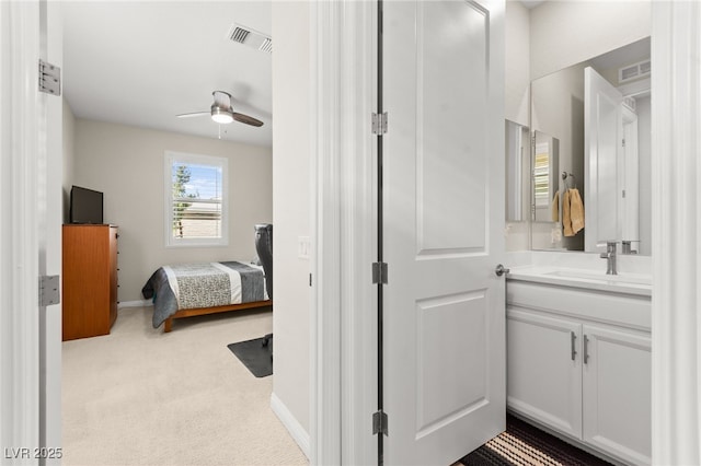 bathroom with baseboards, visible vents, vanity, and ceiling fan