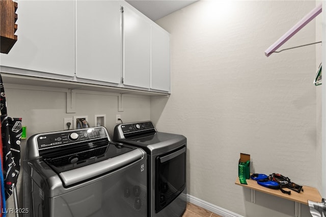 clothes washing area featuring baseboards, cabinet space, light wood finished floors, and independent washer and dryer