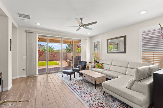 living room with a ceiling fan, wood finished floors, baseboards, visible vents, and recessed lighting