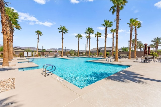 pool with fence, a patio area, and a mountain view