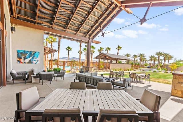 view of patio featuring outdoor dining area, a mountain view, and an outdoor living space