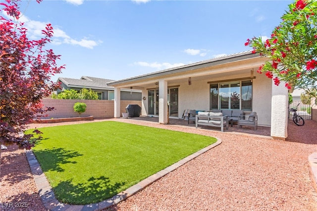 back of property with fence, a yard, a patio, stucco siding, and an outdoor living space