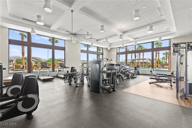 workout area featuring visible vents, a ceiling fan, a towering ceiling, and coffered ceiling