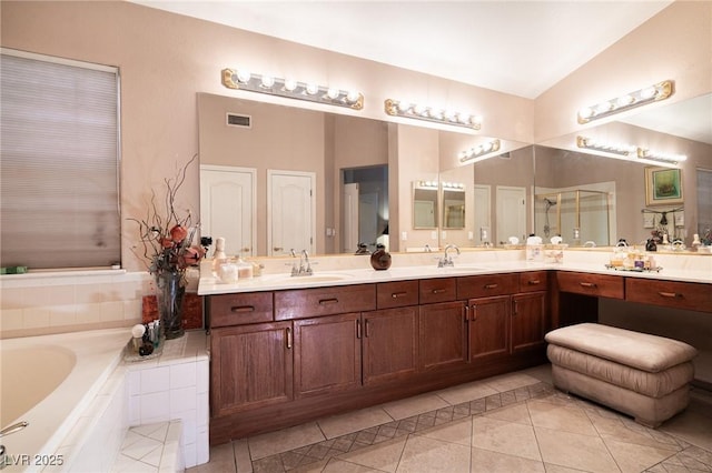 full bathroom featuring tile patterned floors, visible vents, vaulted ceiling, and a sink