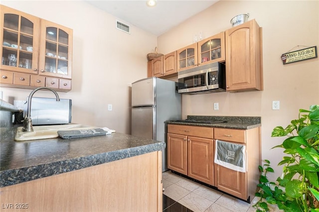 kitchen featuring glass insert cabinets, dark countertops, visible vents, and stainless steel appliances