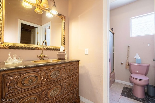 bathroom with toilet, vanity, marble finish floor, and baseboards