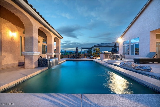 pool at dusk featuring a fenced in pool and a patio area