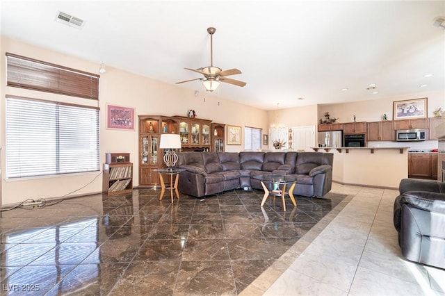 living area featuring visible vents, ceiling fan, marble finish floor, and plenty of natural light