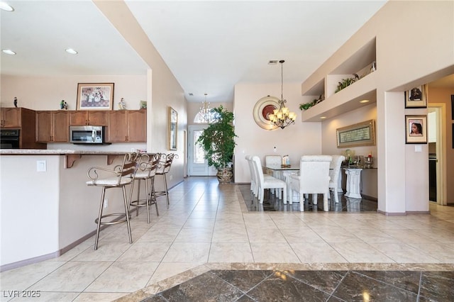 dining space featuring recessed lighting, a notable chandelier, marble finish floor, and baseboards
