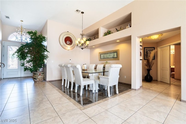 dining room with light tile patterned floors, visible vents, a notable chandelier, and a high ceiling