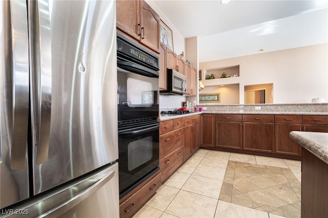 kitchen with light stone countertops, stainless steel appliances, light tile patterned flooring, and recessed lighting