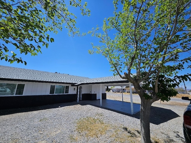 view of front of house with a shingled roof and an attached carport