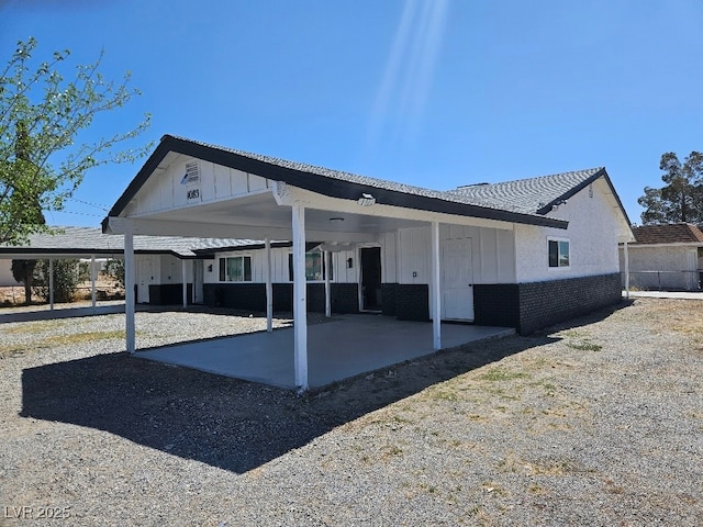 rear view of property featuring board and batten siding and an attached carport