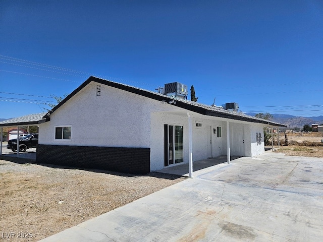 rear view of property featuring central AC, a patio area, and stucco siding