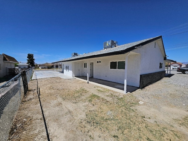 rear view of property with cooling unit, a patio area, stucco siding, and fence