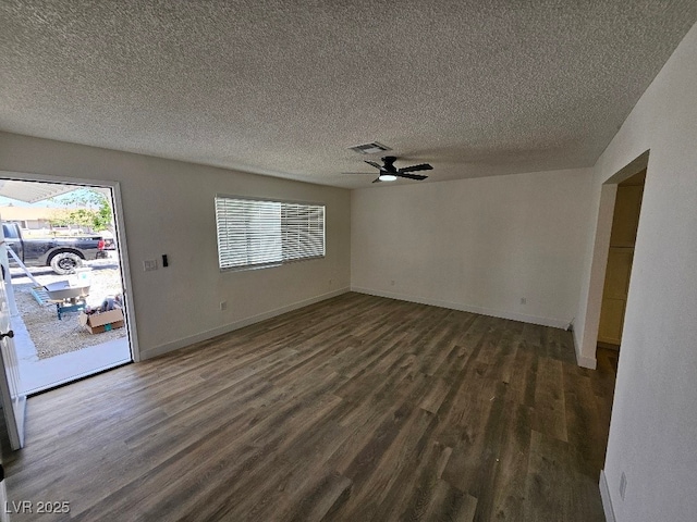 unfurnished living room featuring ceiling fan, dark wood finished floors, a textured ceiling, and visible vents