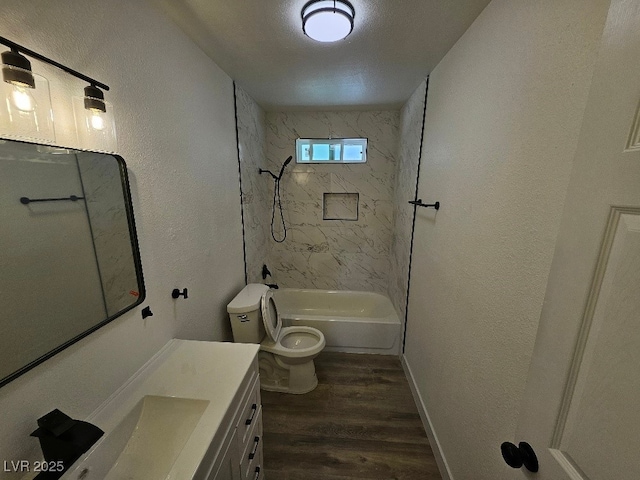 bathroom with a textured wall, washtub / shower combination, vanity, toilet, and wood finished floors