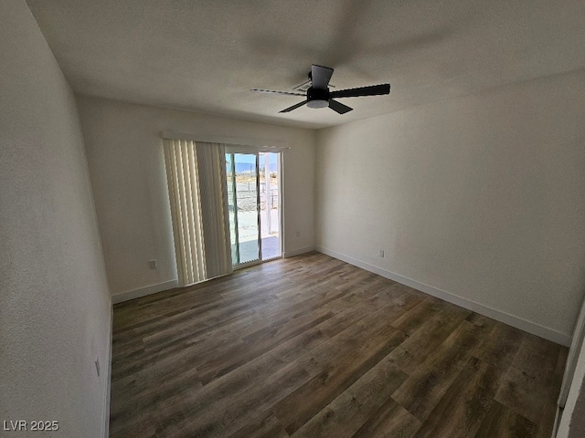 unfurnished room with baseboards, a ceiling fan, and dark wood finished floors