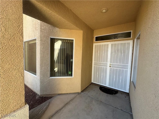 doorway to property featuring a patio area and stucco siding