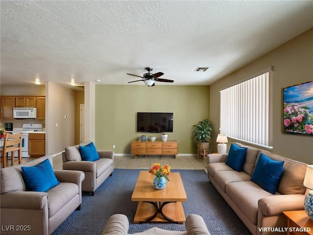 living area featuring visible vents, a ceiling fan, light tile patterned floors, baseboards, and a textured ceiling
