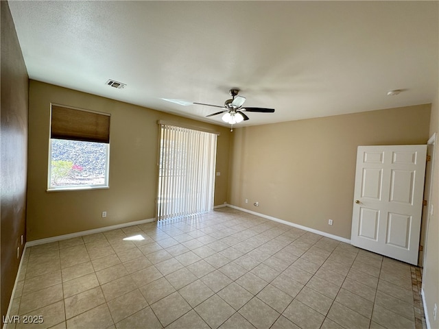 empty room featuring baseboards, a ceiling fan, visible vents, and light tile patterned floors