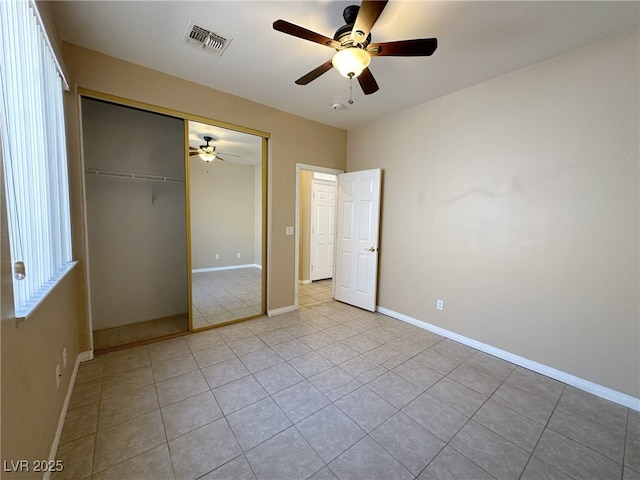 unfurnished bedroom featuring baseboards, visible vents, a closet, ceiling fan, and light tile patterned floors