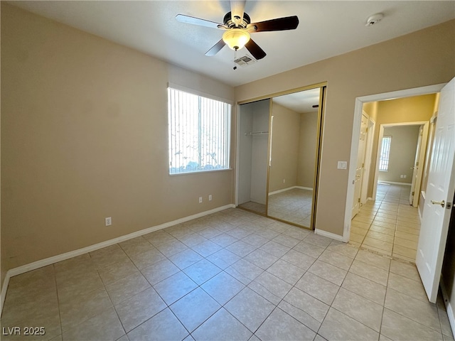 unfurnished bedroom with a ceiling fan, a closet, light tile patterned flooring, baseboards, and visible vents