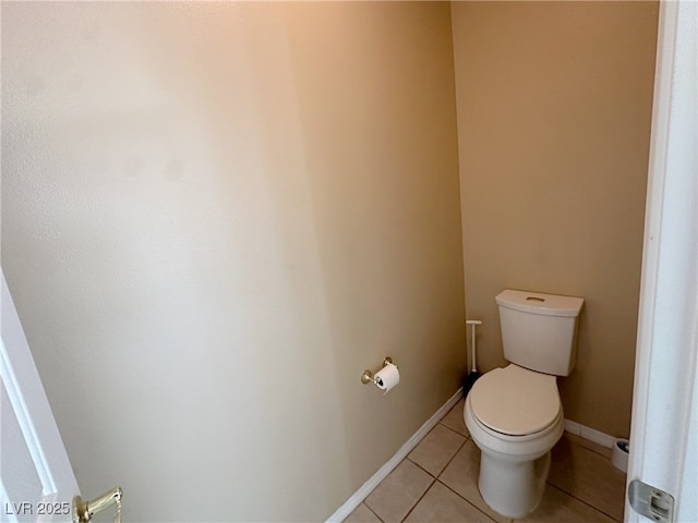 bathroom featuring tile patterned flooring, baseboards, and toilet