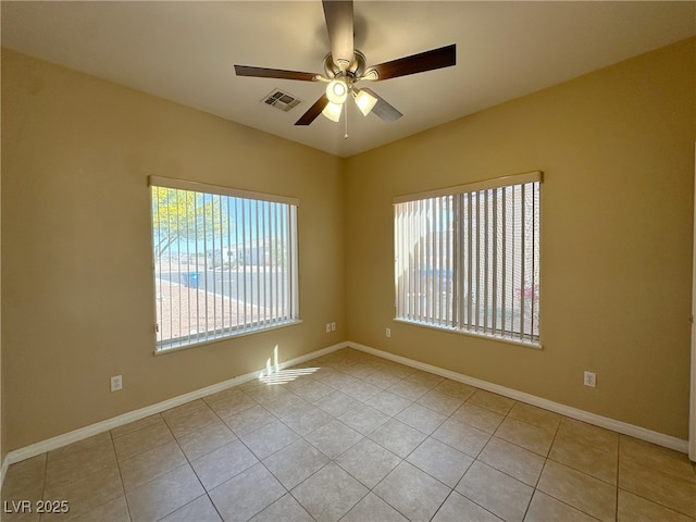 empty room with baseboards, a ceiling fan, tile patterned flooring, and visible vents