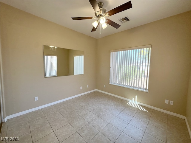 unfurnished room featuring baseboards, a ceiling fan, visible vents, and light tile patterned floors