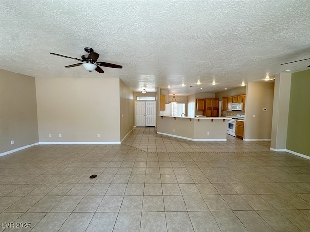 unfurnished living room featuring a ceiling fan, baseboards, light tile patterned flooring, and a textured ceiling