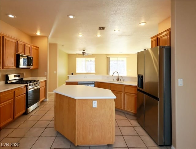 3567 Cottage Stream Ct, Laughlin, NV 89029 - kitchen with appliances with stainless steel finishes, a sink, light countertops, a kitchen island, and light tile patterned floors