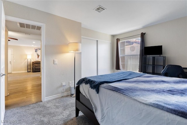 bedroom featuring baseboards, visible vents, carpet floors, and a closet