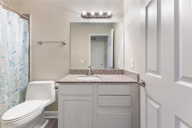 2606 S Durango Dr Unit 260, Las Vegas, NV 89117 - bathroom featuring toilet, vanity, a textured wall, and curtained shower