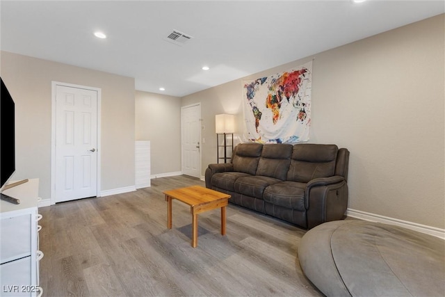 living area with baseboards, wood finished floors, visible vents, and recessed lighting