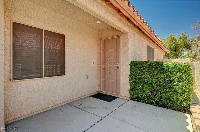 8028 Hurricane Cove Ct, Las Vegas, NV 89129 - property entrance with stucco siding, a tiled roof, and a patio