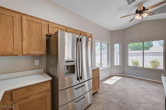 8028 Hurricane Cove Ct, Las Vegas, NV 89129 - kitchen with vaulted ceiling, brown cabinets, ceiling fan, stainless steel refrigerator with ice dispenser, and light countertops