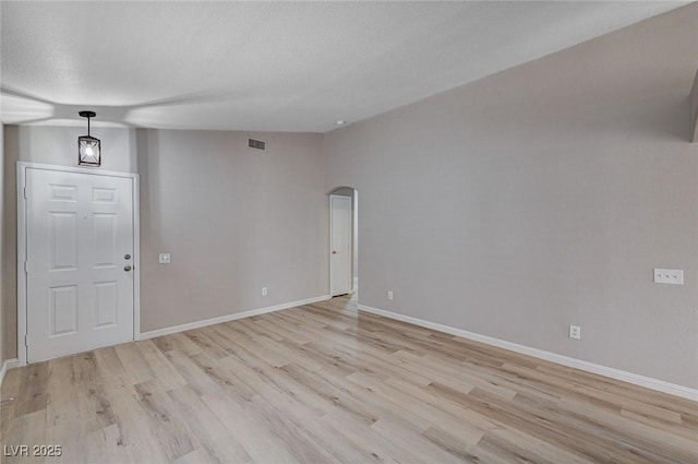 8028 Hurricane Cove Ct, Las Vegas, NV 89129 - empty room with arched walkways, light wood-type flooring, and baseboards