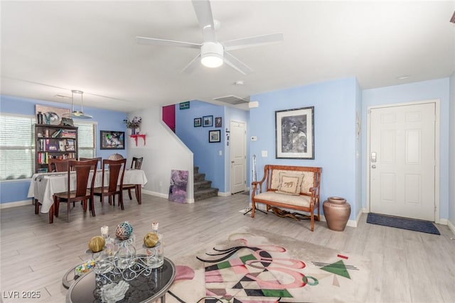 living area featuring stairway, wood finished floors, and visible vents