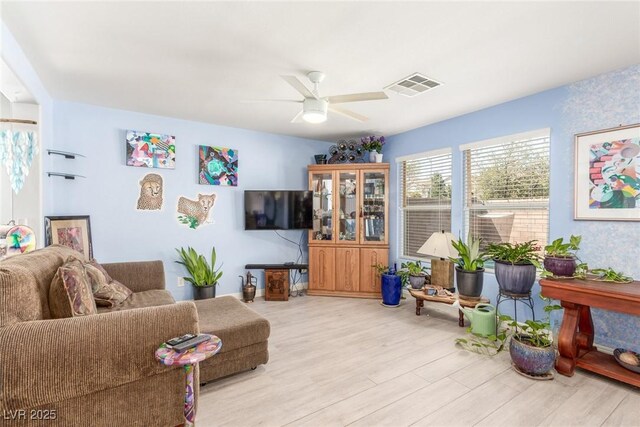 living area featuring ceiling fan, wood finished floors, and visible vents
