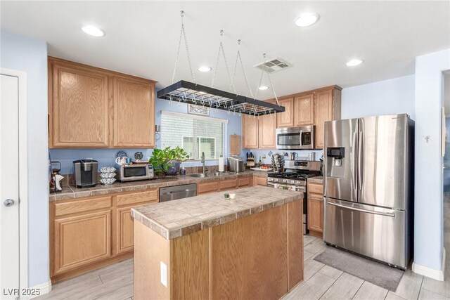 kitchen with recessed lighting, visible vents, a sink, a center island, and appliances with stainless steel finishes