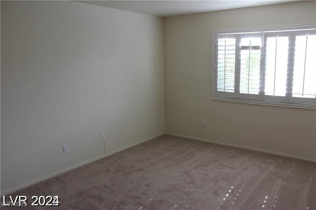 unfurnished room with baseboards and carpet floors
